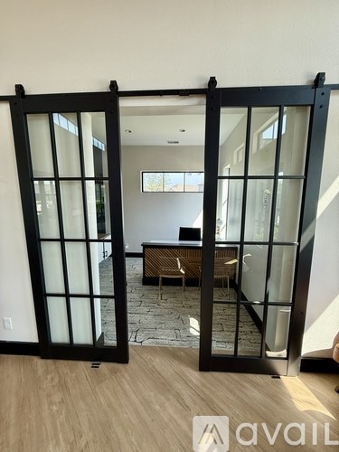 A room with a wooden floor and a glass door leading to a staircase.
