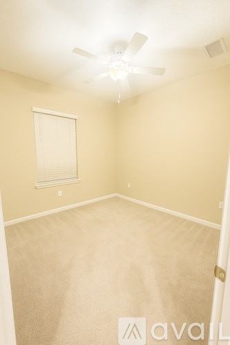 A room with a ceiling fan and carpeted floor.