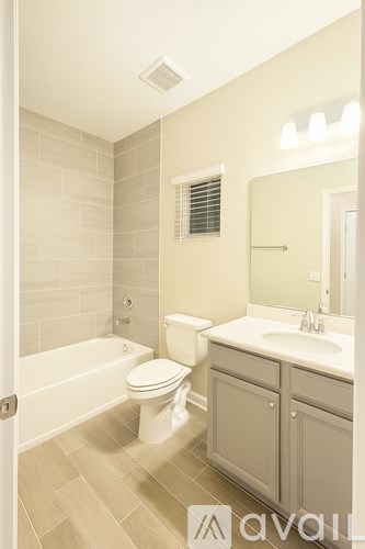 A bathroom with a toilet, sink, and bathtub.