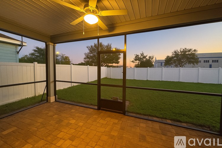 A patio with a ceiling fan and sliding glass doors.