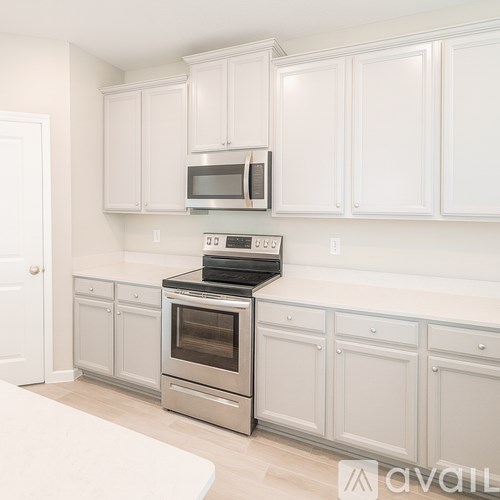 A kitchen with white cabinets and a stainless steel oven.