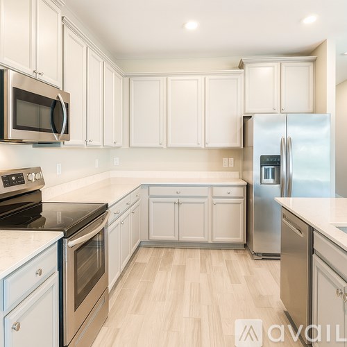 A kitchen with white cabinets and stainless steel appliances.