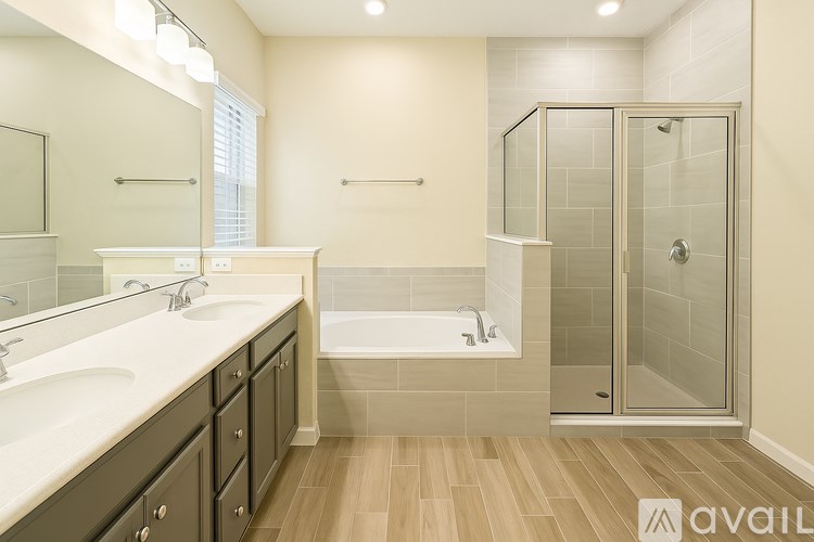 A bathroom with a tub, sink, and shower.