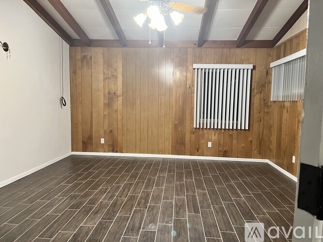 A room with wooden walls and a ceiling fan.