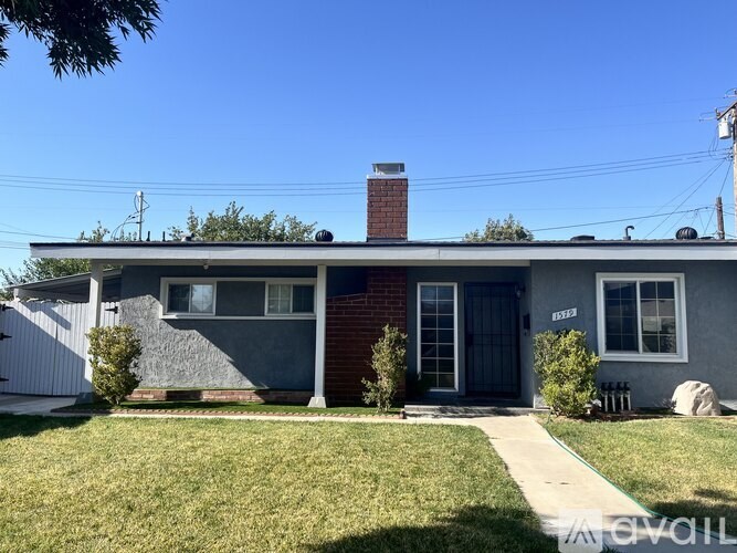 A house with a blue door and a brick chimney.