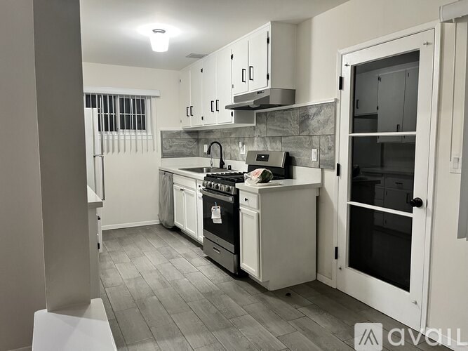 A kitchen with a stove, oven, and sink.