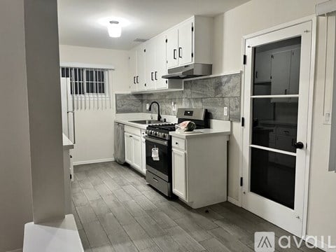 A kitchen with a stove, oven, and sink.