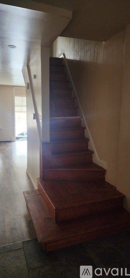A wooden staircase with a carpeted floor.