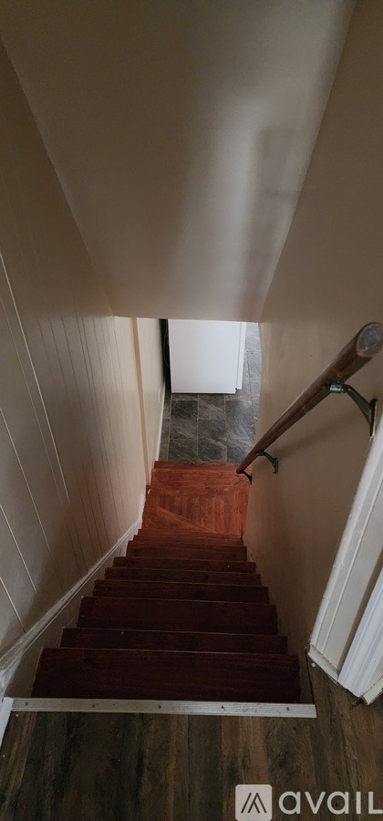 A staircase with wooden steps and a metal handrail.