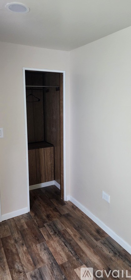 A room with a wooden floor and a white wall.