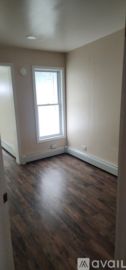 A room with wooden floors and a window.