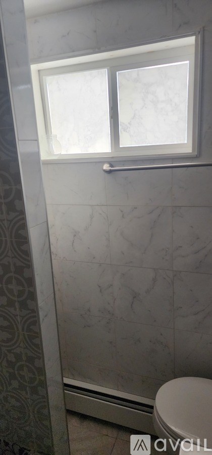 A bathroom with a toilet and a window.