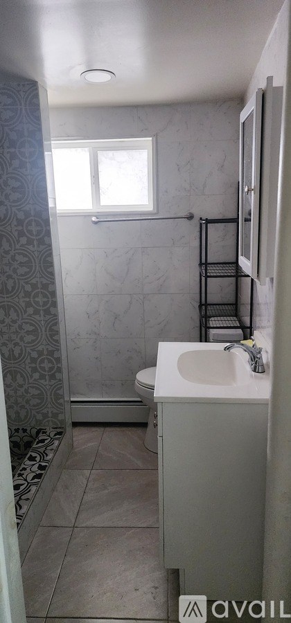 A bathroom with a toilet, sink, and shower.