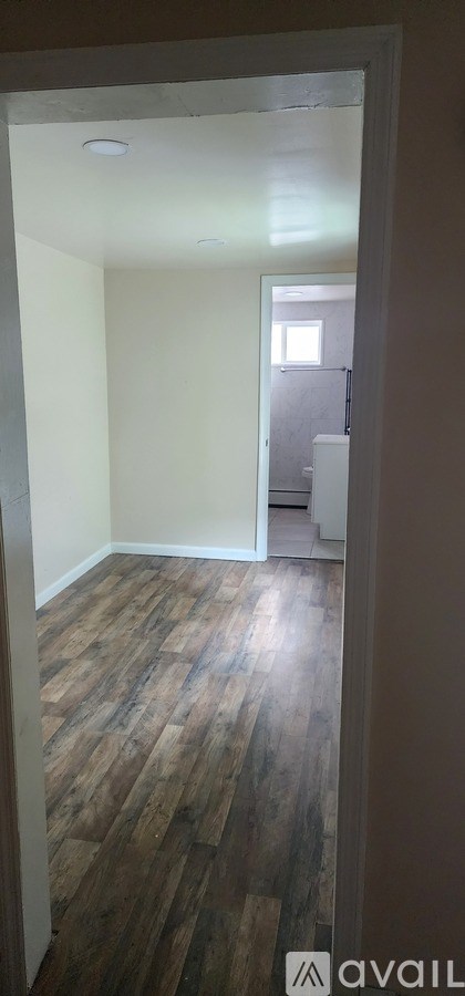 A room with wooden flooring and white walls.
