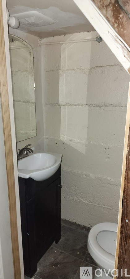 A bathroom with a toilet, sink, and a shower stall.