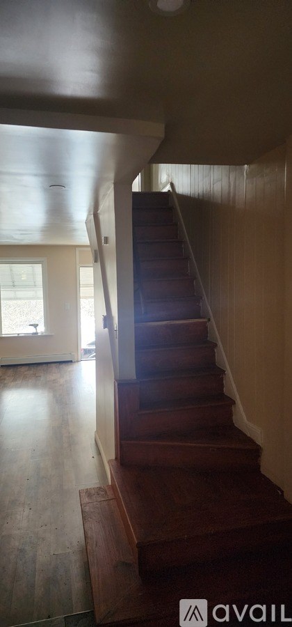A staircase with wooden steps and a light brown wall.