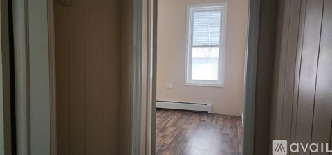 A room with a window and wooden floors.