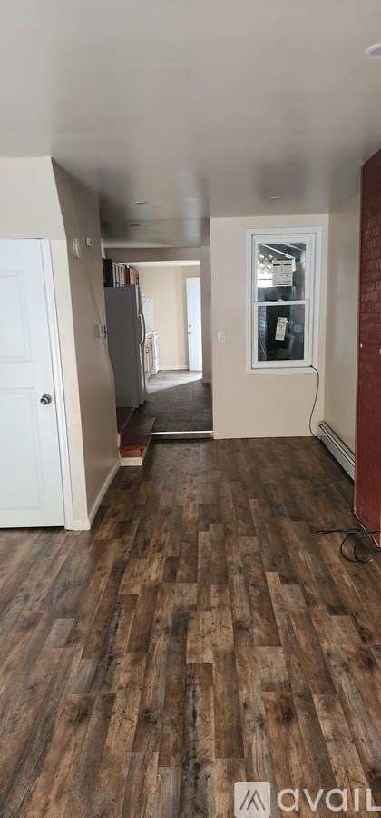 A room with wooden flooring and a white door.