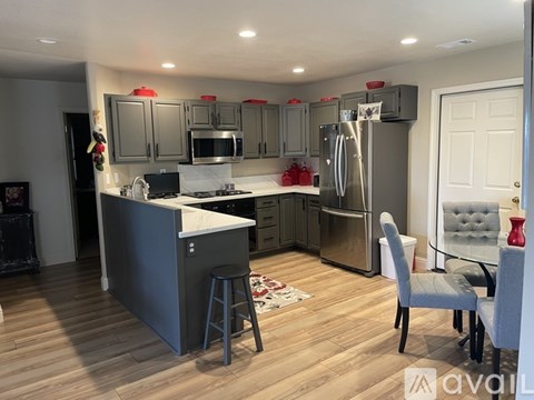 A kitchen with a refrigerator, stove, and cabinets.