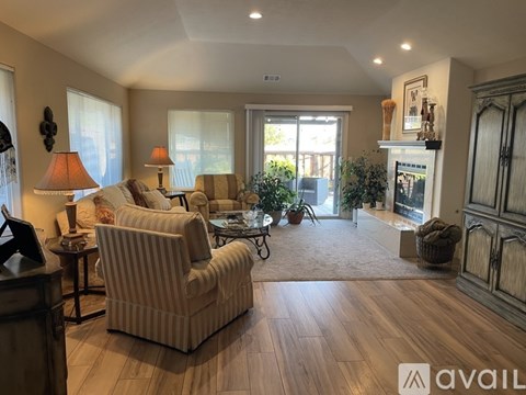 A living room with a striped sofa, a coffee table, and a large window.