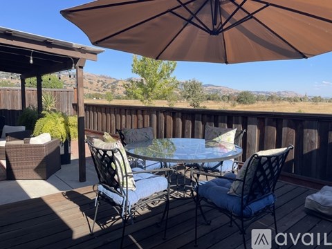 A patio with a table and chairs under an umbrella.