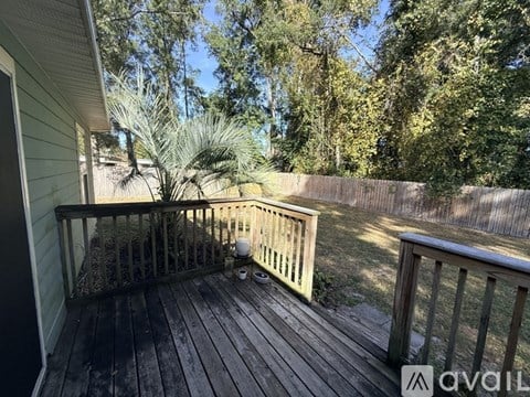 A wooden deck with a railing and a potted plant.