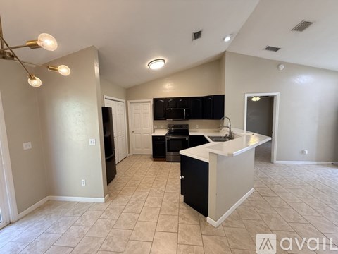 A kitchen with black cabinets and a white island.