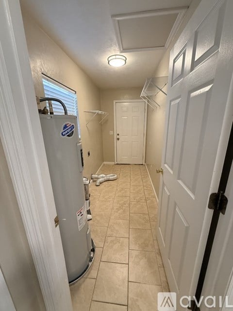 A bathroom with a water heater and a door.