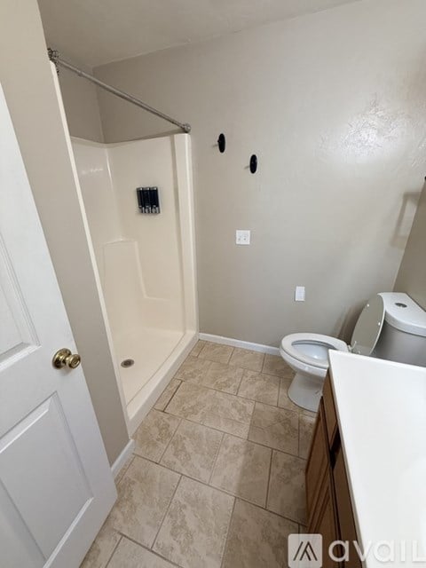 A bathroom with a toilet, sink, and shower.