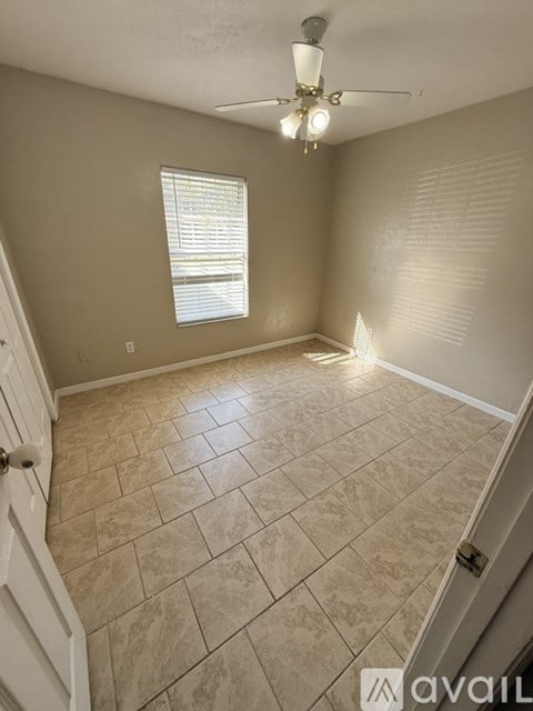 A room with a tiled floor and a ceiling fan.