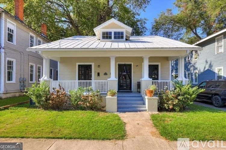 A white house with a porch and a covered entrance.