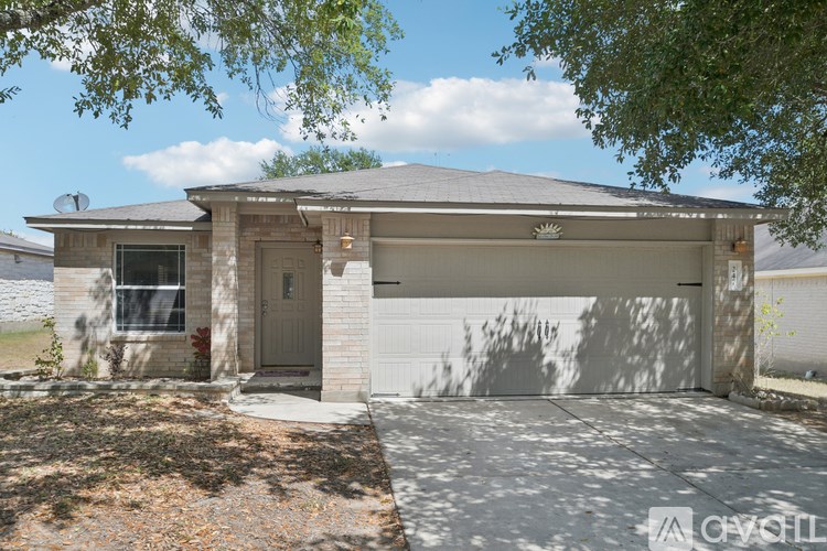 A small house with a grey roof and a white garage door.