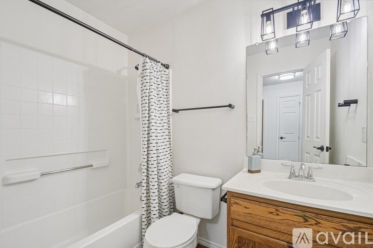 A bathroom with a white toilet, a white sink, and a white bathtub with a shower curtain.