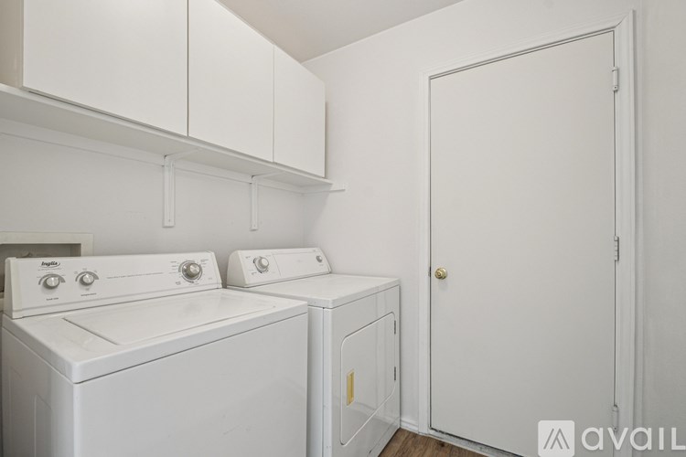 A white laundry room with a washer and dryer.