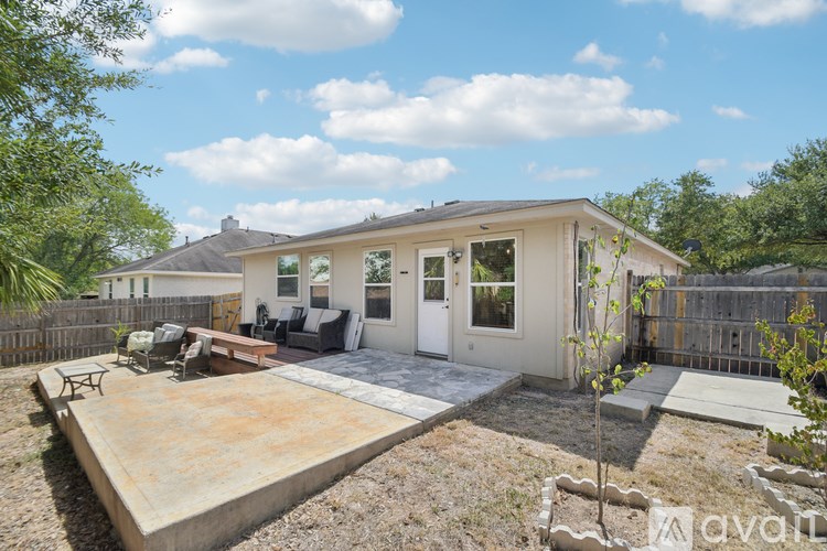 A house with a patio and a tree in front.