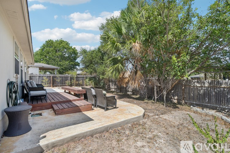 A backyard with a wooden table and chairs.