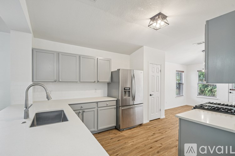 A kitchen with a sink, stove, and refrigerator.