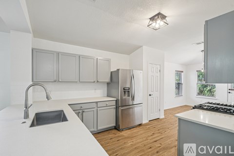 A kitchen with a sink, stove, and refrigerator.