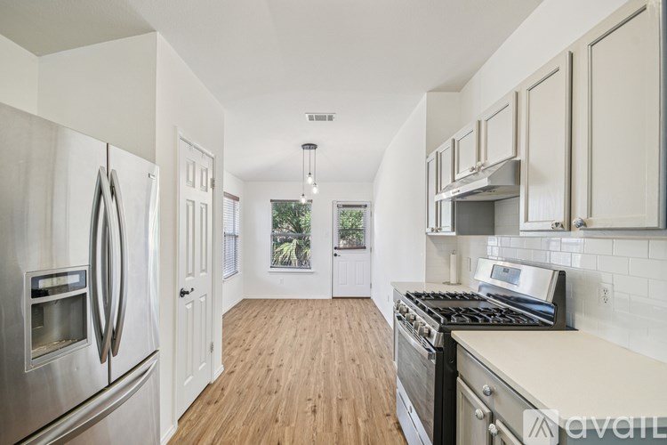 A kitchen with wooden floors and stainless steel appliances.