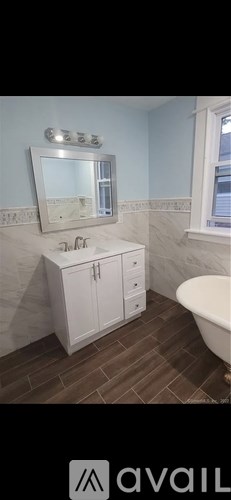 A bathroom with a white cabinet and a mirror above the sink.
