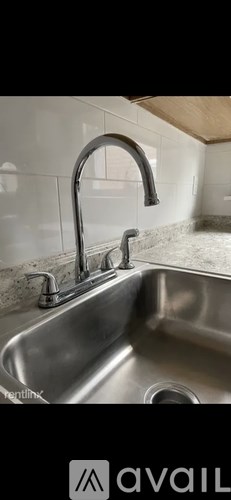 A kitchen sink with a chrome faucet.