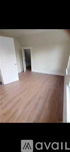A room with wooden flooring and white walls.