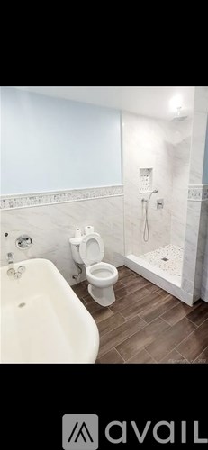 A bathroom with a toilet, sink, and shower.