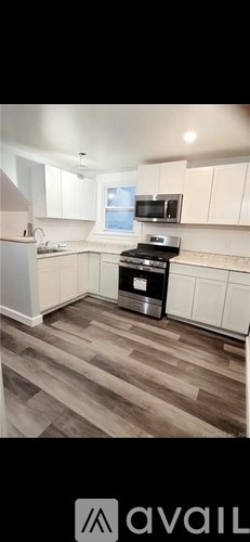 A kitchen with white cabinets and a black stove top oven.