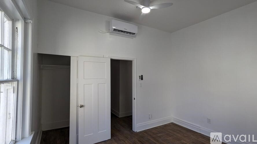 A room with a white door and a window with curtains.