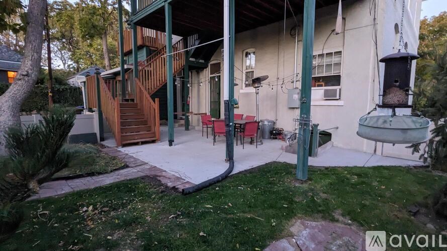 A house with a green pole and a red chair in front of it.