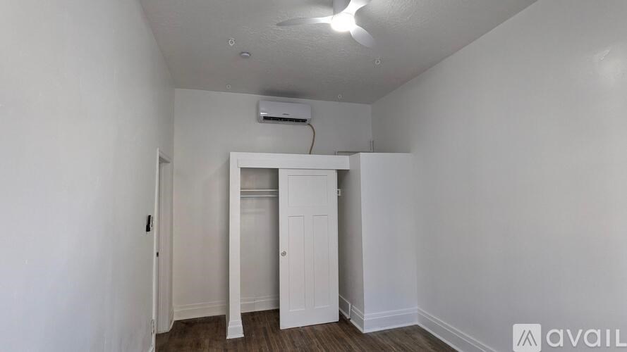 A room with a white door and a window with blinds.