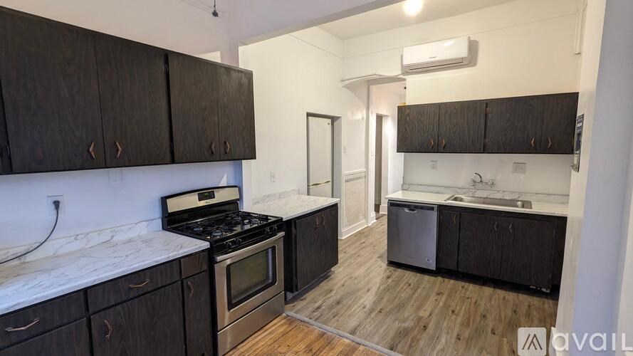 A kitchen with dark wood cabinets and a white marble countertop.