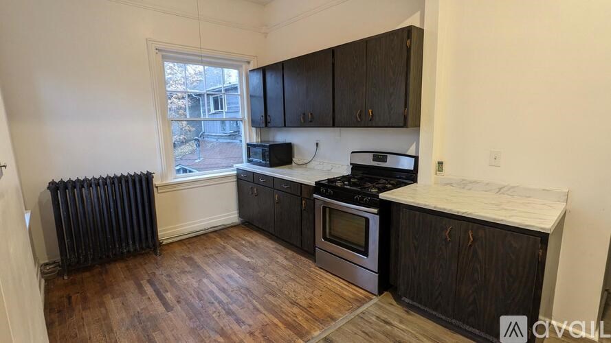 A kitchen with dark wood cabinets and a white countertop.