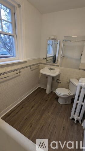 A small bathroom with a toilet, sink, and mirror.